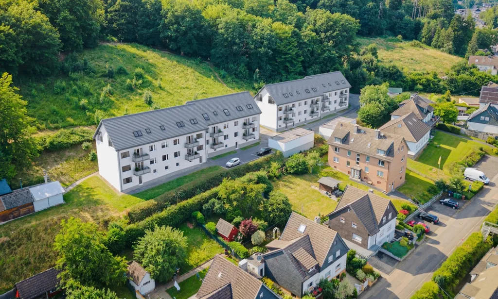 Eine Luftaufnahme zeigt moderne Kapitalanlage in einer grünen Umgebung, die als Kapitalanlage für potenzielle Käufer interessant sind