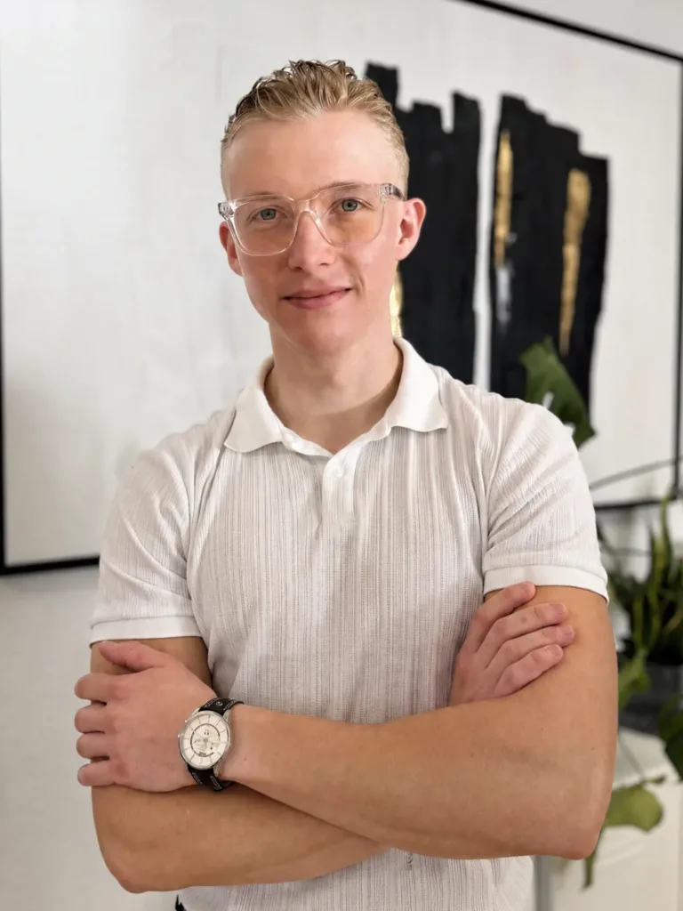 Gedeon Tägtmeyer steht mit verschränkten Armen im Büro von BetonGold Immobilien und vermittelt Selbstbewusstsein und Professionalität